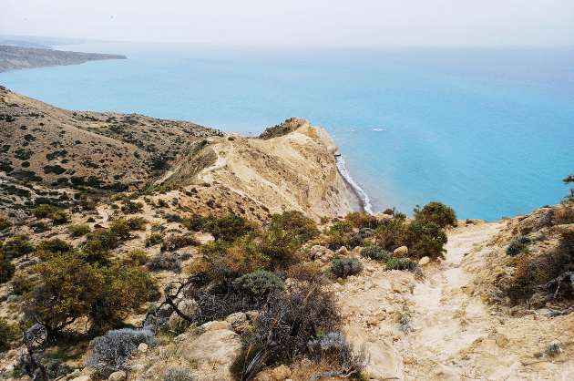 Sziklás túraösvény a Cape Aspro túraútvonalon Pissouri közelében, magas partfalakkal és türkizkék tengeri kilátással Cipruson