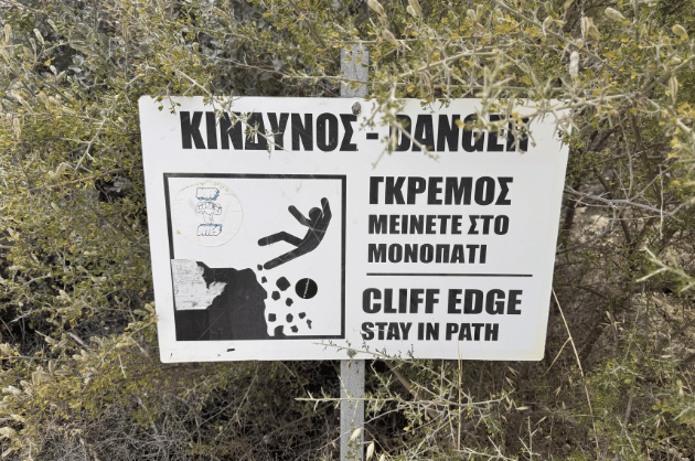 Figyelmeztető tábla a Cape Aspro túraútvonalon Pissouri közelében, amely a sziklaperem veszélyére hívja fel a figyelmet